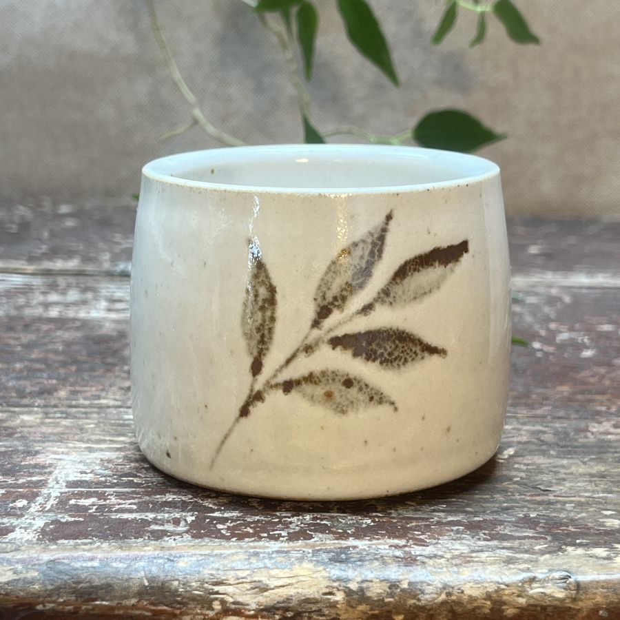 Bílý kalíšek s motivem lístků