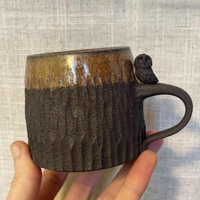 Tmavý hrnek se sýčkem