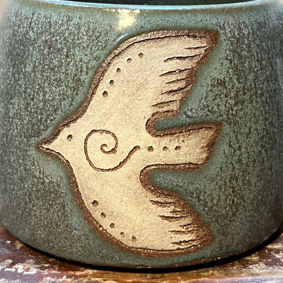 Zelenkavý hrnek se zasněným ptáčkem