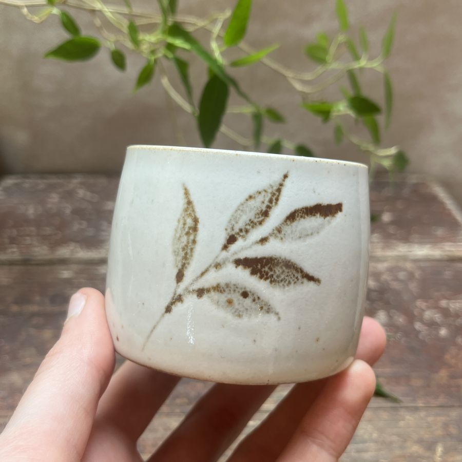 Bílý kalíšek s motivem lístků