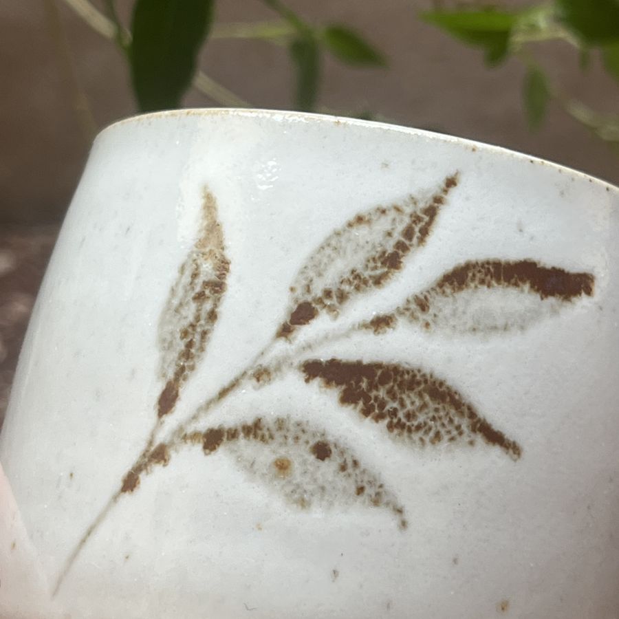 Bílý kalíšek s motivem lístků